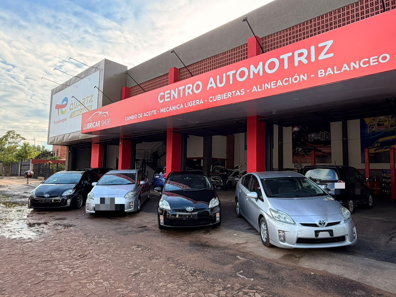 Frente del centro automotriz de Alquila Car con parte de la flota híbrida